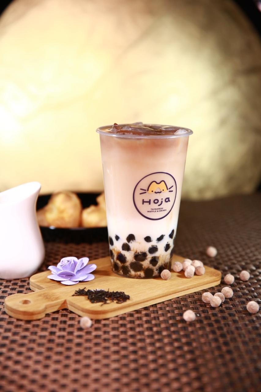 HOJA Bubble Tea mit handgemachten Tapioka-Perlen, frischem Tee und Milch auf einem Holzbrett